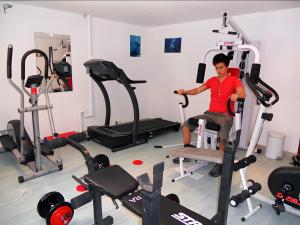 a man sitting on a treadmill in a gym at Le Cyprès - La Fontinelle in Bessas