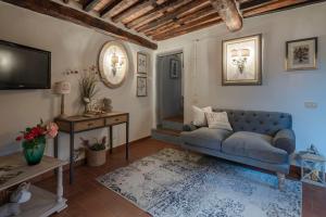 a living room with a blue couch and a television at La Casa del Grillo Parlante in Collodi
