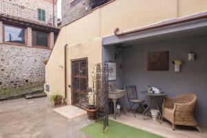 a patio with a table and a chair and a building at La Casa del Grillo Parlante in Collodi