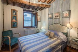 a bedroom with a bed and a chair and a window at La Casa del Grillo Parlante in Collodi
