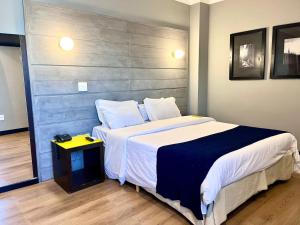 a bedroom with a large bed with a gray headboard at Oasis Tower Hotel in Ribeirão Preto +34 photos