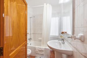 a white bathroom with a sink and a tub at Apto Yurena 10B 2B in Los Llanos de Aridane +15 photos