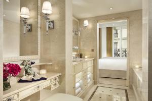 a bathroom with a bed and a sink and a mirror at Hotel Splendide Royal Paris - Relais & Châteaux in Paris