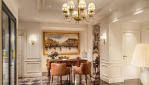 a room with a table, chairs, and a large mirror at Hotel Splendide Royal Paris - Relais & Châteaux in Paris