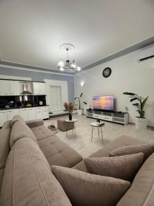 a large living room with a couch and a tv at Himalayas in Gjirokastër