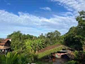 a group of houses with trees and a blue sky at Tudo é Arte Retreat - A Creative Haven Between Nature and Sea in Piçarras