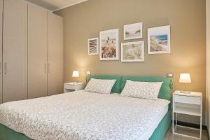 a bedroom with a bed and two lamps and pictures on the wall at Residenza Porta Volta in Milan +36 photos
