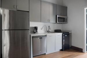 a kitchen with white cabinets and a stainless steel refrigerator at Cute Little Condo no 310 in Dallas +11 photos