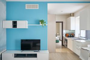 a kitchen with white cabinets and a blue wall at Residenza Porta Volta in Milan