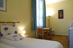 a bedroom with a bed and a table and a window at Le Nid - Studios in Chartres