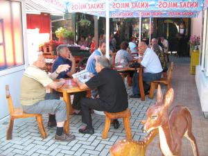 un groupe de personnes assises à une table dans un restaurant dans l'établissement SOBE za izdavanje BLEF, à Ovčar Banja