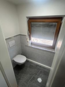 a small bathroom with a toilet and a window at Monteur Zimmer Künzing in Künzing