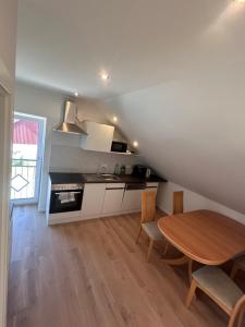 a kitchen and dining room with a wooden table at Monteur Zimmer Künzing in Künzing