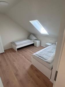 a attic bedroom with two beds and a skylight at Monteur Zimmer Künzing in Künzing +12 photos