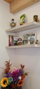a shelf with a bouquet of flowers and books at Antico Borgo Fonzaso in Fonzaso