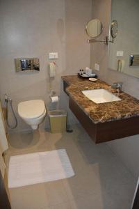 a bathroom with a sink and a toilet and a counter at Hotel Natraj in Dibrugarh