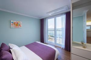 a bedroom with a bed and a large window at Yeongduk Brie Pension in Yŏngdŏk