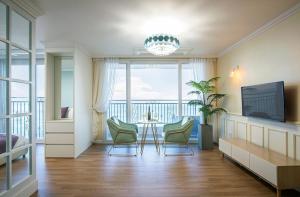 a room with a table and chairs and a balcony at Yeongduk Brie Pension in Yŏngdŏk