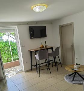 a living room with a table and a tv on the wall at Apartman Aurora in Ičići
