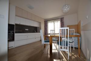 a kitchen with a table and chairs in a room at Sunny apartment in Olomouc