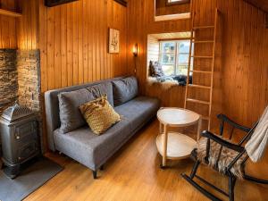 a living room with a couch and a ladder and a stove at Traditional Cabin with Sea View in Stykkið