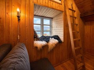 a small room with a window and a ladder at Traditional Cabin with Sea View in Stykkið +9 photos