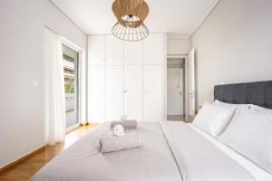 a bedroom with a large white bed with a towel on it at City Center Calm Spot in Athens