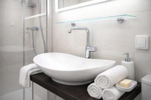 a bathroom with a white sink and a shower at APSTAY central station I Self Check-in I Parking option in Graz
