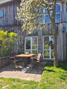 a table and chairs under a tree in a yard at Sonniges Sundchalet in Stralsund
