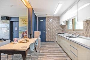 a kitchen with a table and a sink in it at Daebudo sunshine kids poolvilla in Ansan +2 photos