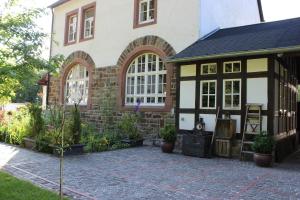 a house with a patio in front of it at Eifel-Quartiere "Pension Müscher Bahnhof" in Müsch