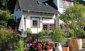 a house with a table and chairs in front of it at Eifel-Quartiere "Pension Müscher Bahnhof" in Müsch