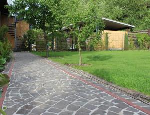 a cobblestone walkway with a tree in a yard at Eifel-Quartiere "Pension Müscher Bahnhof" in Müsch