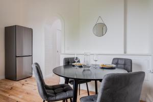 a dining room with a table and chairs and a refrigerator at Potsdam Classic Apartment in Potsdam +20 photos
