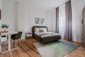 a bedroom with a bed and a desk and a table at Potsdam Classic Apartment in Potsdam
