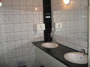 a bathroom with two sinks and a mirror at SOBE za izdavanje BLEF in Ovčar Banja