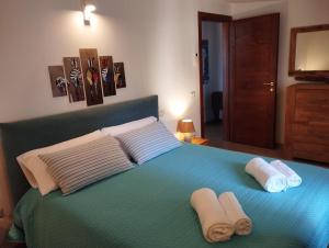 a bedroom with a blue bed with towels on it at Cara a' mari in Castelsardo