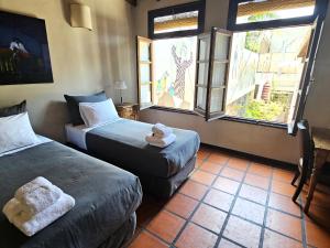 a hotel room with two beds and two windows at Posada Gotan in Buenos Aires