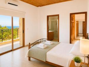 a bedroom with a bed and a balcony at Villa Androulla in Argaka +24 photos