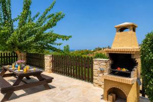 a patio with a stone pizza oven and a table at Villa Androulla in Argaka