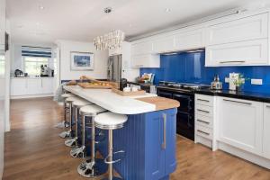 a kitchen with a blue island with bar stools at Stucktaymore in Killin