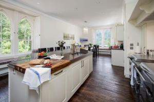 a kitchen with white cabinets and a wooden counter top at Stuckgowan in Arrochar