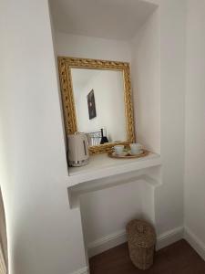 a mirror on a wall with a counter with a sink at La dolce vita in Zelbio +21 photos
