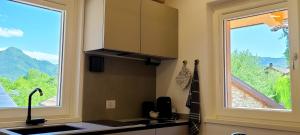 a kitchen with a sink and a large window at Antico Borgo Fonzaso in Fonzaso