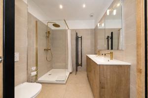 a bathroom with a shower and a toilet and a sink at HDG Hôtel Gare de L'Isle Adam Appart's Hotel in Parmain +45 photos