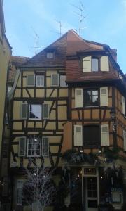 un edificio alto con una casa con ventanas en Appart chaleureux en Colmar