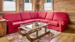 a red couch in a living room with a coffee table at Chalet Sozzine in Ponte di Legno