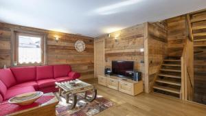 a living room with a red couch and a tv at Chalet Sozzine in Ponte di Legno