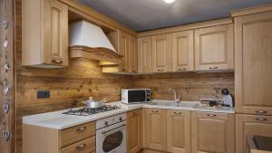 a kitchen with wooden cabinets and a stove top oven at Chalet Sozzine in Ponte di Legno