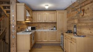 a kitchen with wooden cabinets and a stove top oven at Chalet Sozzine in Ponte di Legno